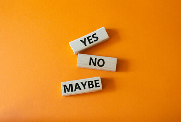 Yes No Maybe symbol. Concept word Yes No Maybe on wooden blocks. Beautiful orange background....