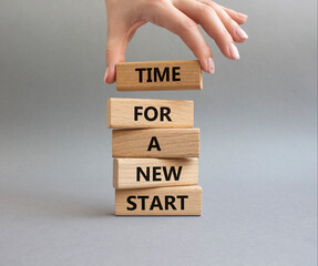 Time for a new start symbol. Wooden blocks with words Time for a new start. Beautiful grey...