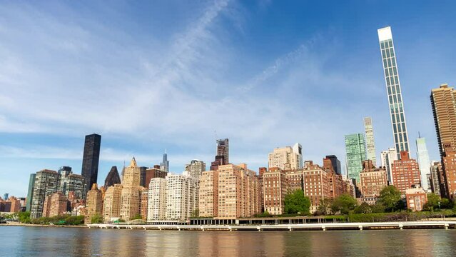 New York city skyline time lapse - midtown Manhattan and upper east side hyper lapse. Waterfront cityscape of urban metropolis downtown with tall buildings in the United States of America.
