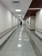 Empty modern hospital corridor, clinic hallway interior background with white chairs for patients...
