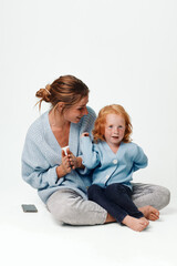 Family time mother and daughter sitting on floor with cell phone, leisure, technology, connection, bonding, relaxation