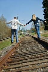 Couple Walking On Railroad Tracks