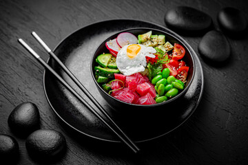 Tuna Poke bowl composition on black background. The Art of Japanese Cuisine. Food photography for menu and sushi bar decoration