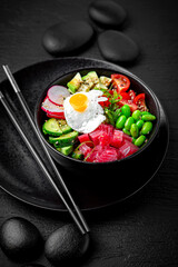 Tuna Poke bowl composition on black background. The Art of Japanese Cuisine. Food photography for menu and sushi bar decoration