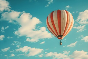 Fototapeta premium Hot air balloon against a blue sky with clouds. Summer travel and adventure concept. Beautiful landscape. Design for banner, wallpaper, poster with copy space