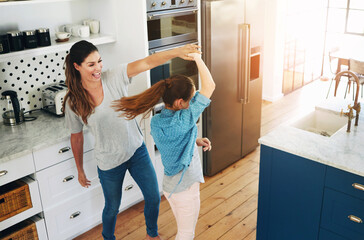 Happy, mother and girl dance in kitchen with love, care and support in family or home on weekend....