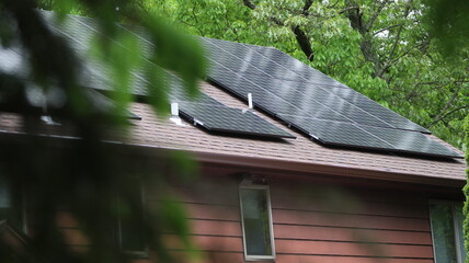 Solar Panels on top of modern home with tree foreground