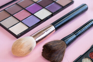 Makeup brushes and color palettes, close-up shot, focus on brushes