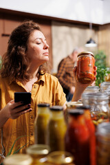 Healthy living woman in zero waste store using smartphone notes app to check shopping list....