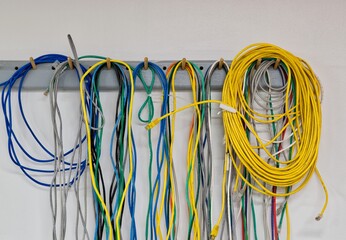 Colorful electrical cords wall hanging CAT5 Twisted pair cable computer networks.	