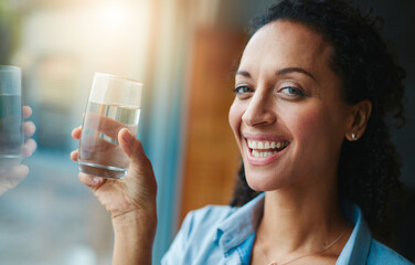 Woman, portrait and happy in home with glass of water for wellness, wellbeing and hydration. Smile,...