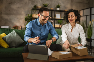 Mature woman and adult man check packets on clipboard at home