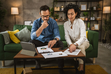 Two colleagues man and woman work on economy project together at home