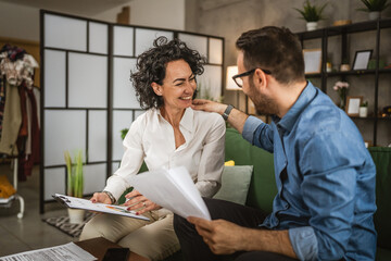 Fototapeta premium Two colleagues man and woman work on economy project together at home
