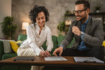 Mature woman sign insurance or contract to adult man at home