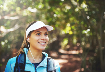 Earphones, thinking and happy woman hiking in nature on outdoor adventure to explore on holiday...