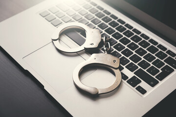 Handcuffs on the laptop, cyber crime concept