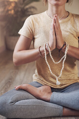 Hands, meditation and peace with beads on floor for woman with yoga, balance and mindfulness in...