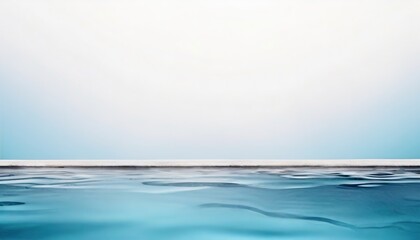 Obraz premium Serene sea with calm waters, under a clear sky with a smooth gradient from blue to white, conveying tranquility and open space.
