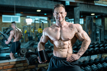 Fototapeta na wymiar muscular bodybuilding athlete with perfect body holding protein or whey jar mockup in gym, athletic man with torso in fitness club holding sport nutrition and supplement