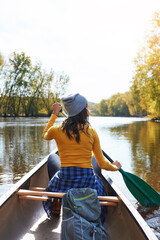 Woman, back and canoeing for fitness sport in nature, wellness hobby and single blade paddle for rowing. Vacation, relax and explore exercise on travel for summer holiday, canoe boat and river