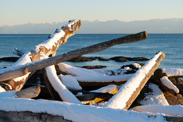 A snow covered beach on Vancouver Island looking across the Pacific to the Olympic Mountains