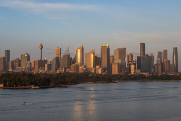 Fototapeta premium Extraordinary view of Sydney's Icons, namely the Sydney Opera House, Sydney Harbor Bridge and Sydney Downtown, while arriving by cruise ship in a beautiful sunrise.