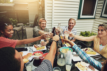 Friends, toast and lunch at party, backyard or happy for food, diversity or celebration on patio....