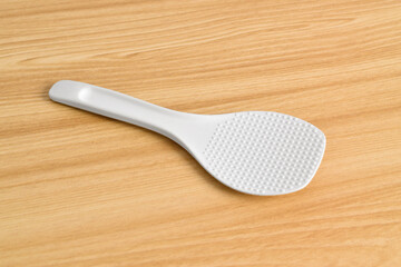 White rice spoon or rice ladle on wooden table. White plastic rice paddle