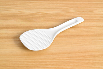 White rice spoon or rice ladle on wooden table. White plastic rice paddle