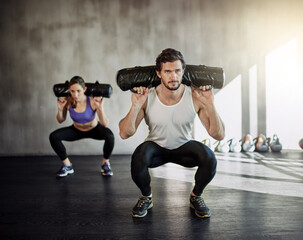Man, woman and squat with sandbag for gym exercise or leg strength for muscle building, discipline...