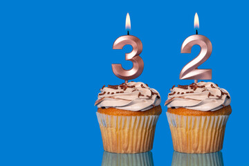Birthday Cupcakes With Candles Lit Forming The Number 32.