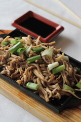 Shimeji mushrooms on a plate: petite, yet potent with earthy flavor, their slender stems and delicate caps offering a delightful addition to any dish, whether stir-fried or served raw.