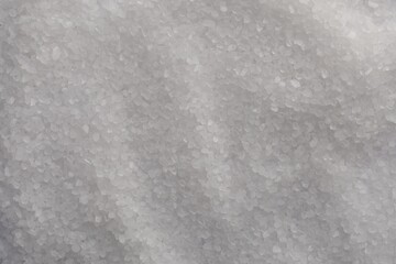 White natural salt as background, top view