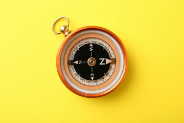 One compass on yellow background, top view