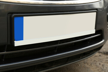 Car with vehicle registration plate outdoors, closeup