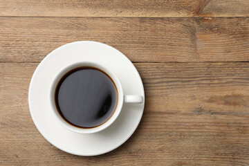 Cup of aromatic coffee on wooden table, top view. Space for text