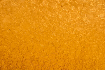 Closeup macro shot of foam bubbles in yellow water
