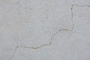 A grey and white wall with a crack in it
