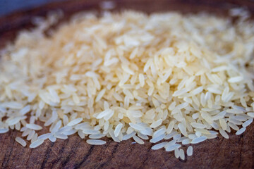 Very close-up photo of parboiled rice grains on wooden board