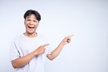Potrait Of Excited Young Asian Guy Pointing To Side For Advertisement Isolated On White Background
