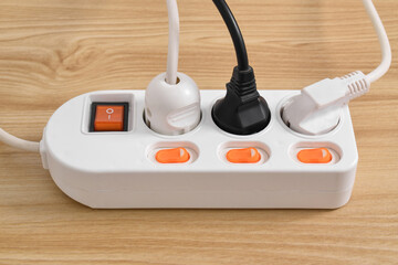 Electrical plug in outlet socket at home isolated on on wooden table, Outlet, Electric Plug, Power Cable, a power button and a connected electrical plug