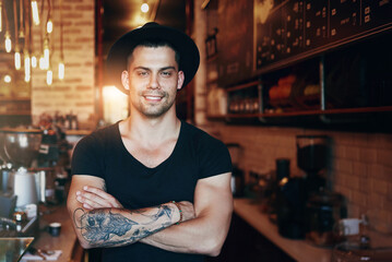 Portrait, smile and man with arms crossed in cafe as barista with startup confidence, restaurant or...