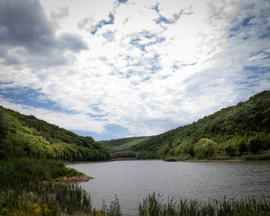 Beautiful view of a lake from its shore during a hike on a sunny summer day.