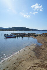 光り射す古ぼけた桟橋と舟縦構図