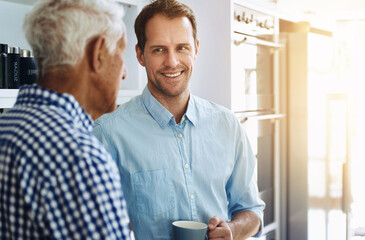 Man, happy and senior father in kitchen with conversation in morning with coffee for bonding in...