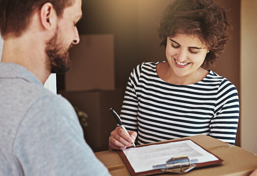 Woman, home and smile with signing for delivery or package, parcel and courier with moving in. Female person, new house and boxes with paperwork or document for shipment, mail and cargo with contract