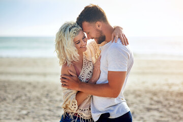Smile, couple and hug by ocean with love for seaside romance, serene seascape and beach view with...