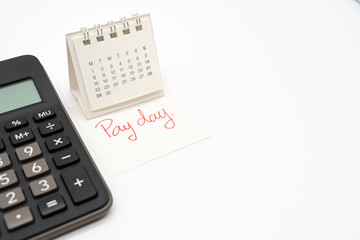 For payday concept. Desk calendar, calculator and paper note in isolated background. Business,...