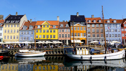 COPENHAGEN, DENMARK, APRIL 27, 2024: Copenhagen iconic view. The popular Nyhavn port area with the colorful houses in the center of Copenhagen, Denmark during spring season sunny day